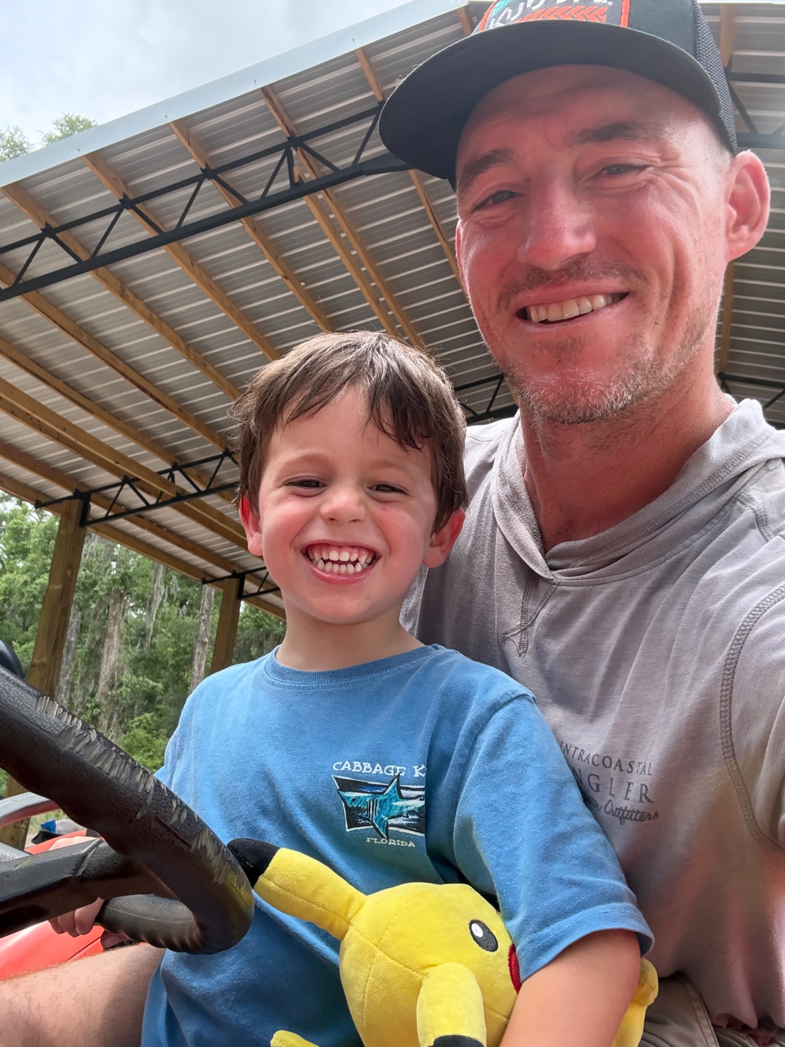A father and son smiling together at the farm